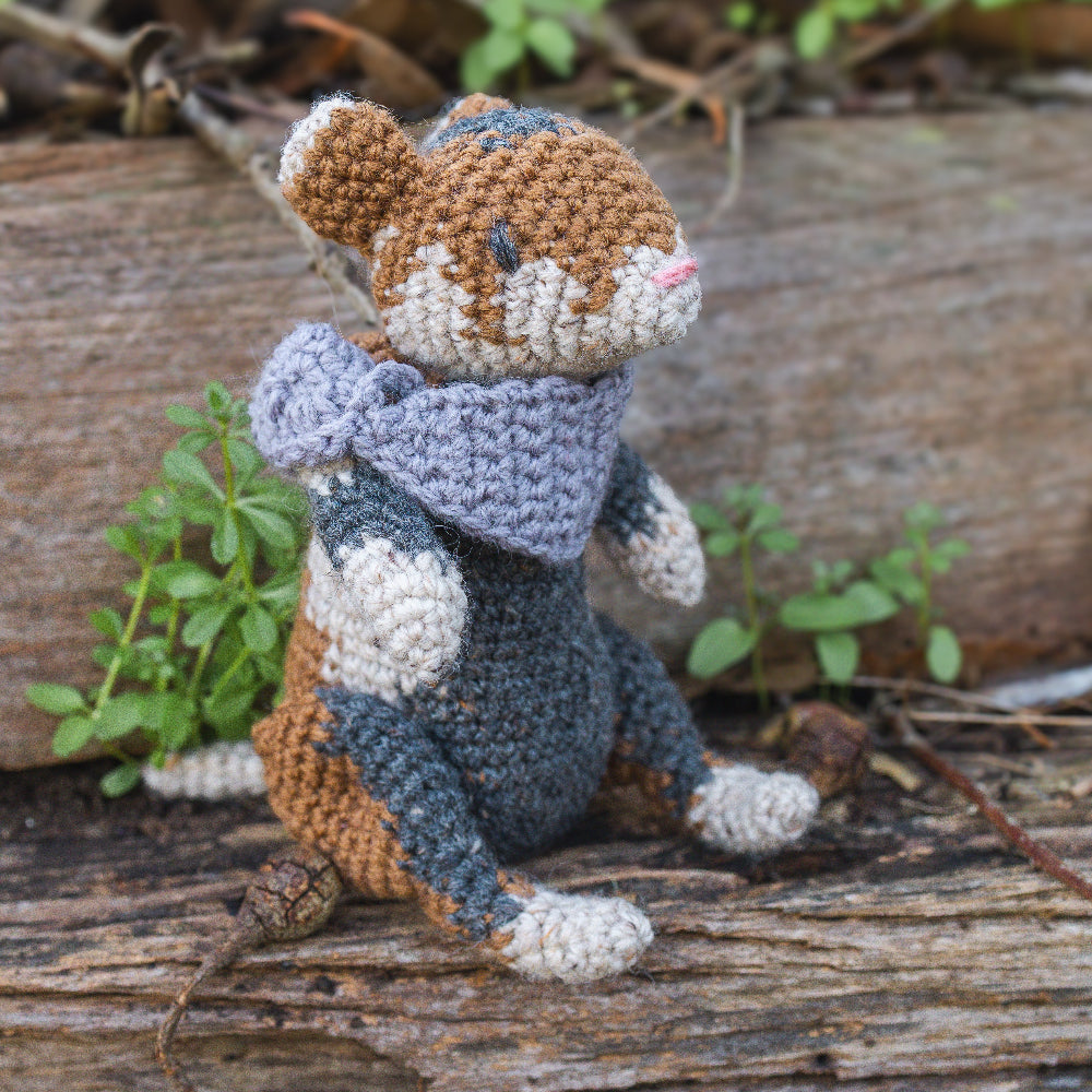 Amigurumi crochet medieval fantasy hamster sitting in nature with armour on