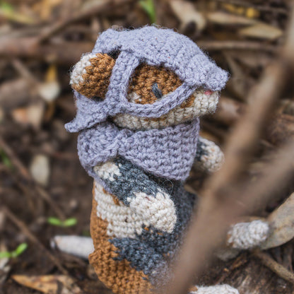 Amigurumi crochet medieval fantasy hamster with helmet sitting in nature